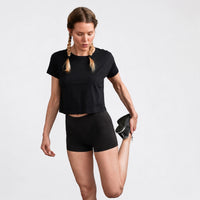 Femme en boxer s'étirant la jambe gauche avec son bras gauche