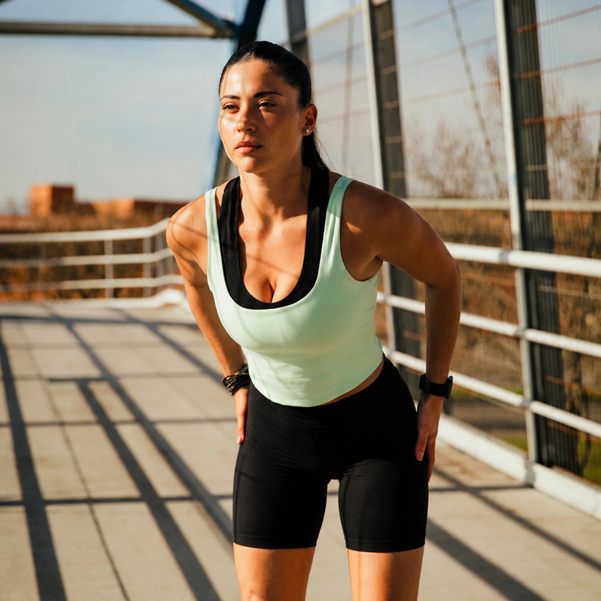 Femme en tenue de sport se tenant les hanches pendant une session de running