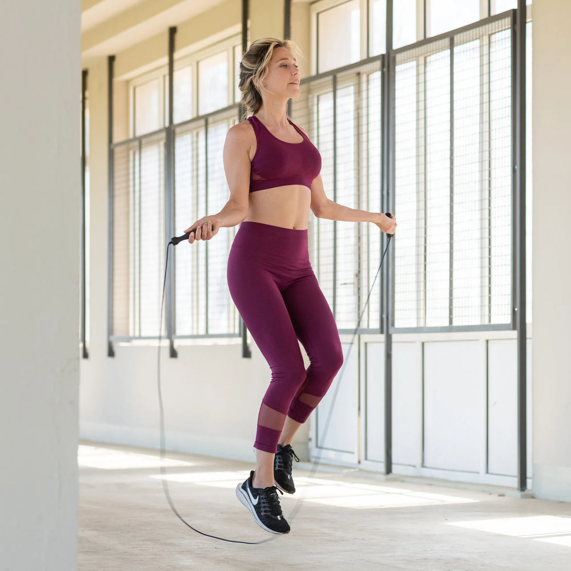 Femme en tenue de sport en train de faire de la corde à sauter