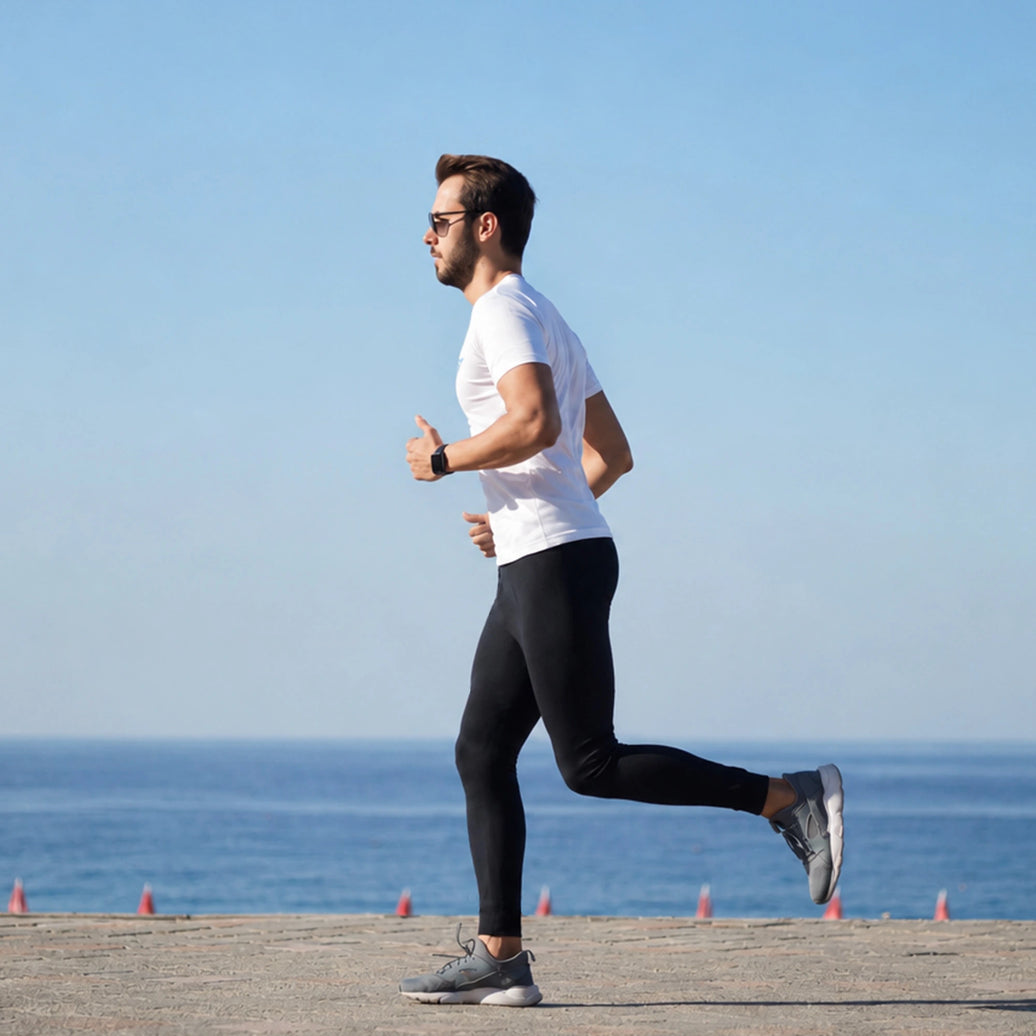 Homme en legging en train de courir au bord de la mer