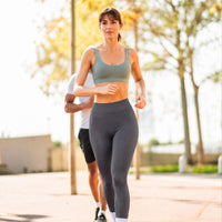 Femme en legging gris faisant du legging avec un homme dans un park
