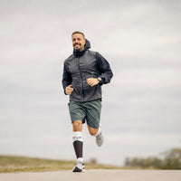 Homme en train de courir sur la route avec des manchons de mollet