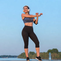 Femme faisant des étirements au bord de l'eau avec un footing